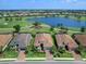 Stunning aerial view of home on golf course with lake view and beautifully landscaped yard, surrounded by lush greenery at 15037 Montello Way, Lakewood Ranch, FL 34211