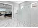 This modern bathroom offers a frameless glass shower with multiple shower heads and marble flooring at 15037 Montello Way, Lakewood Ranch, FL 34211