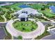 Aerial view of elegant clubhouse with lush landscaping, circular driveway, and golf course views at 15037 Montello Way, Lakewood Ranch, FL 34211