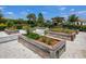 Bright community garden with wooden planter boxes and winding stone walkways among lush landscaping at 15037 Montello Way, Lakewood Ranch, FL 34211