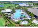 Aerial view of resort-style community pool with palm trees, lounge chairs, cabanas, and lush landscaping at 15037 Montello Way, Lakewood Ranch, FL 34211