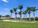Community entrance sign surrounded by lush tropical landscaping and tall palm trees on a sunny day at 15037 Montello Way, Lakewood Ranch, FL 34211