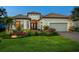 Well-maintained home featuring manicured landscaping and double front doors and warm exterior lighting at 15037 Montello Way, Lakewood Ranch, FL 34211