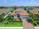Charming home with double door entry, lush landscaping, brick driveway and view of the golf course and lake at 15037 Montello Way, Lakewood Ranch, FL 34211