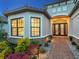 Charming home exterior features stone accents, lush landscaping, and inviting double door entry with sidelights at 15037 Montello Way, Lakewood Ranch, FL 34211