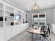 Beautiful home office with custom built-ins, a modern desk, and a comfortable chair at 15037 Montello Way, Lakewood Ranch, FL 34211