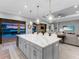 Modern kitchen with a large island, pendant lighting, and sliding doors to the outdoor living space at 15037 Montello Way, Lakewood Ranch, FL 34211