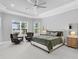 Serene main bedroom with tray ceiling, neutral colors, and large windows overlooking the water at 15037 Montello Way, Lakewood Ranch, FL 34211