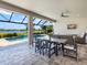 An outdoor dining area offers a great view of the pool and backyard for elegant open-air entertaining at 15037 Montello Way, Lakewood Ranch, FL 34211