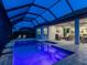 Covered and screened pool and patio area with an outdoor living space at twilight at 15037 Montello Way, Lakewood Ranch, FL 34211