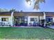 Villa's rear view with a brick patio perfect for relaxation, complemented by a lush green lawn and serene outdoor living space at 1526 Mission Hills Blvd # 18B, Clearwater, FL 33759