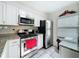Well-equipped kitchen with white cabinets, granite countertops, and stainless steel appliances, providing a modern and efficient cooking area at 1526 Mission Hills Blvd # 18B, Clearwater, FL 33759