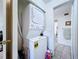 Compact laundry area with stacked washer and dryer, adjacent to a bathroom at 1526 Mission Hills Blvd # 18B, Clearwater, FL 33759