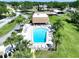 Aerial view of the community pool and patio with lounge chairs and shade at 1526 Mission Hills Blvd # 18B, Clearwater, FL 33759