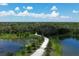 Scenic aerial view of the property's long driveway, surrounded by lush greenery and two serene ponds at 15518 29Th E St, Parrish, FL 34219
