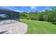 Expansive backyard featuring a screened lanai and lush green lawn with mature trees at 15518 29Th E St, Parrish, FL 34219