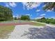 Outdoor basketball court with green and red playing surface, surrounded by trees and blue skies at 15518 29Th E St, Parrish, FL 34219