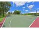 Green outdoor basketball court surrounded by mature trees and blue skies with white clouds at 15518 29Th E St, Parrish, FL 34219