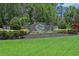 Welcoming Twin Rivers community entrance with stone signage, beautiful plants, and landscaping at 15518 29Th E St, Parrish, FL 34219