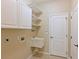 Well-lit laundry room featuring ample cabinet space, utility sink, and neutral color palette at 15518 29Th E St, Parrish, FL 34219