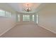Spacious living room with a tray ceiling, neutral carpet, and multiple windows at 15518 29Th E St, Parrish, FL 34219