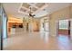 Open-concept living space with a tray ceiling, tile floors, and views of the kitchen at 15518 29Th E St, Parrish, FL 34219