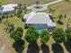 Overhead shot of a home with a screened-in pool, surrounded by mature landscaping and green lawn at 17343 Cayo Ln, Punta Gorda, FL 33955