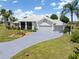 Charming single-story home featuring a three-car garage, white tile roof and beautiful landscaping at 17343 Cayo Ln, Punta Gorda, FL 33955