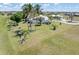 Aerial view showcasing a single-Gathering home with a screened lanai, surrounded by palm trees and lush lawn at 17343 Cayo Ln, Punta Gorda, FL 33955