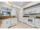 Kitchen featuring white appliances, and light granite countertops at 17343 Cayo Ln, Punta Gorda, FL 33955