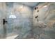 Close up of a tiled shower showcasing the designer blue marble tile and dual shower heads at 17343 Cayo Ln, Punta Gorda, FL 33955