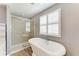Bathroom featuring a soaking tub with shower and large window with shutter-style blinds at 2084 La Palma Ave, Port Charlotte, FL 33953