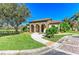 Community clubhouse with stone archways, tile roof, and manicured landscaping near pond at 2084 La Palma Ave, Port Charlotte, FL 33953