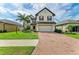 Charming two-story home with brick driveway, well-manicured lawn, and vibrant landscaping at 2084 La Palma Ave, Port Charlotte, FL 33953