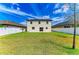 Backyard view of two-story home featuring a well-manicured lawn and modern exterior at 2084 La Palma Ave, Port Charlotte, FL 33953