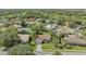 Aerial shot showcasing a home with a red tile roof, surrounded by lush landscaping in a residential neighborhood at 2115 Timucua Trl, Nokomis, FL 34275