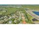 Wide aerial shot of a neighborhood with mature landscaping, a water feature and single Gathering homes at 2115 Timucua Trl, Nokomis, FL 34275