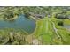 Scenic aerial shot capturing the golf course, lakes and clubhouse with lush greenery and blue skies at 2115 Timucua Trl, Nokomis, FL 34275