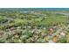 Panoramic aerial view of a residential neighborhood featuring mature landscaping and community golf course at 2115 Timucua Trl, Nokomis, FL 34275