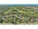 Aerial view of a residential neighborhood with lush greenery and a golf course in the background at 2115 Timucua Trl, Nokomis, FL 34275