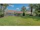Expansive backyard with lush green lawn and screened-in lanai at 2115 Timucua Trl, Nokomis, FL 34275