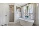 Stylish bathroom featuring a modern tub and glass enclosed shower and large picture window for natural light at 2115 Timucua Trl, Nokomis, FL 34275
