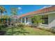 Backyard with a covered, screened lanai, lovely landscaping, and a tile roof at 2115 Timucua Trl, Nokomis, FL 34275