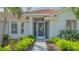 Close-up of front door with decorative security screen and lush green landscaping framing the walkway at 2115 Timucua Trl, Nokomis, FL 34275