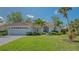Charming single-story home featuring a red tile roof, lush landscaping, and a well-manicured lawn at 2115 Timucua Trl, Nokomis, FL 34275