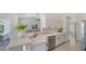 Bright kitchen features white cabinets, stainless steel appliances, and a breakfast bar overlooking the living area at 2115 Timucua Trl, Nokomis, FL 34275