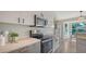 Modern kitchen boasts stainless steel appliances, white cabinets, stone countertops and plenty of natural light at 2115 Timucua Trl, Nokomis, FL 34275