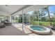 Relaxing screened lanai featuring a jacuzzi, tile flooring, and lovely views of the home's outdoor living space at 2115 Timucua Trl, Nokomis, FL 34275