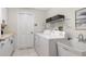 Functional laundry room with washer, dryer, utility sink, and ample cabinet space at 2115 Timucua Trl, Nokomis, FL 34275