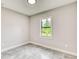 An empty bedroom showcasing a window with natural light and tiled floors throughout the space at 22 Medalist Cir, Rotonda West, FL 33947